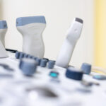 Das Bild zeigt eine Detailaufnahme der Bedieneinheiten eines Ultraschallgerätes mit mehreren Spezialsonden. Das Gerät kommt zum Beispiel im Rahmen der Ultraschalluntersuchung der Brust (Elastographie) zum Einsatz.