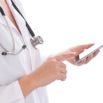 Das Foto zeigt eine Ärztin die ein modernes Handy (PDA) in der Hand hält.